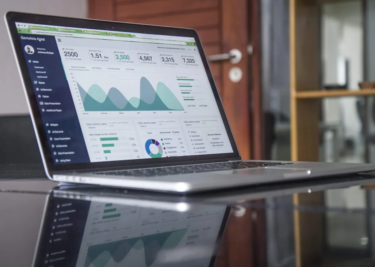Laptop displaying website analytics and charts on a desk.